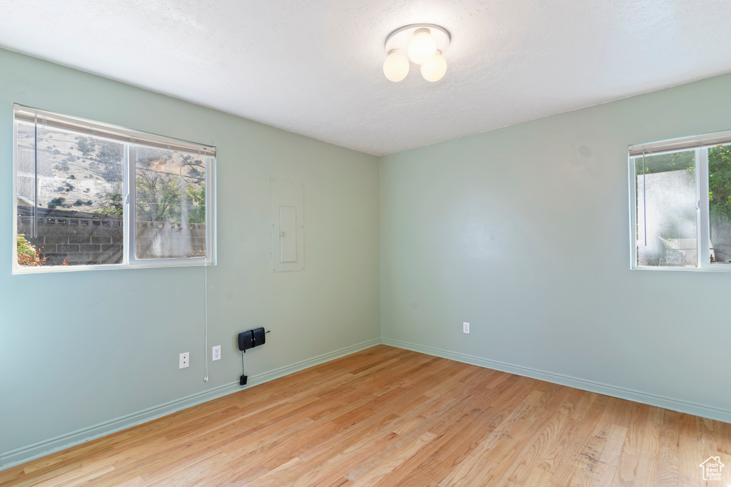 Unfurnished room with light wood-type flooring and electric panel
