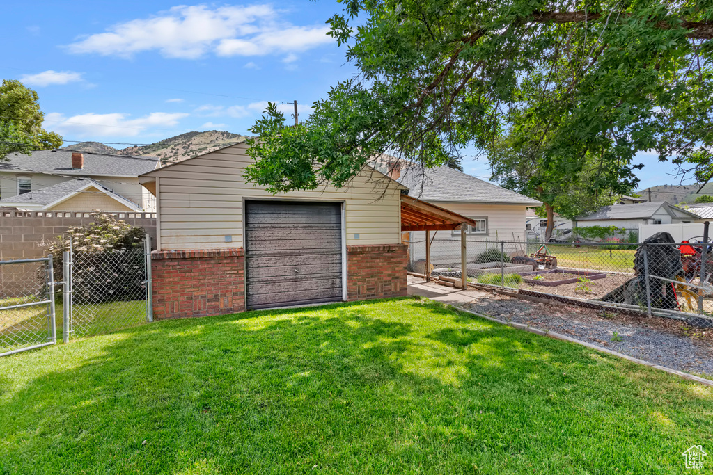 View of yard with an outbuilding, a gate, and a garage