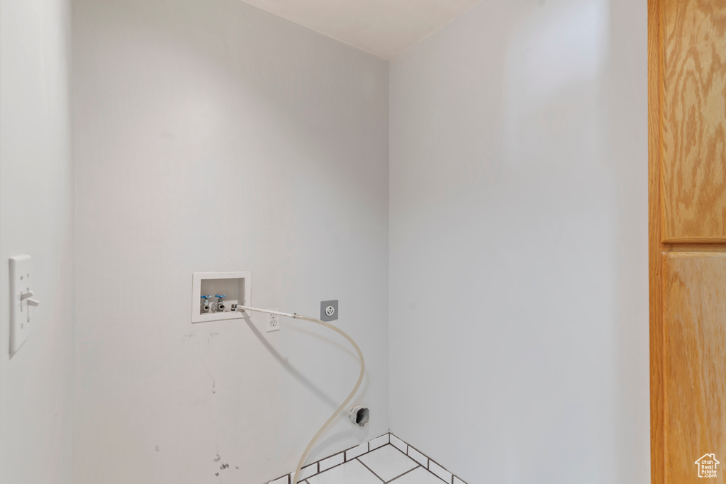 Laundry room with hookup for a washing machine, hookup for an electric dryer, and light tile patterned flooring