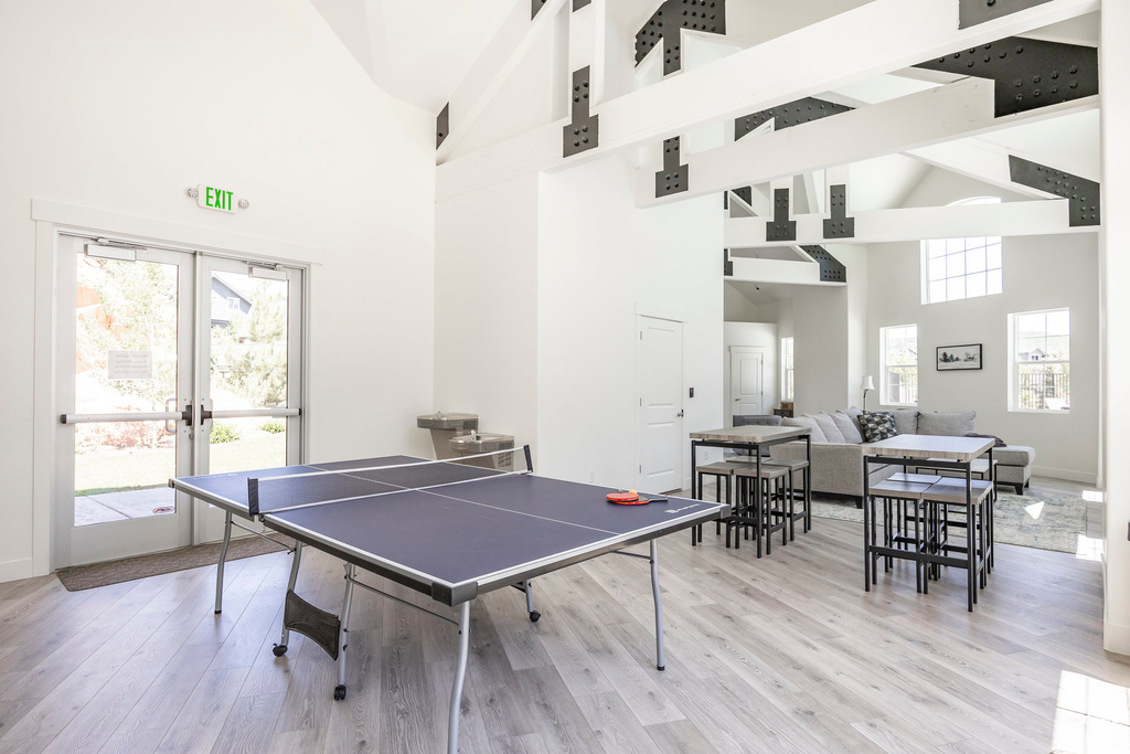 Rec room with high vaulted ceiling, french doors, wood finished floors, and beam ceiling