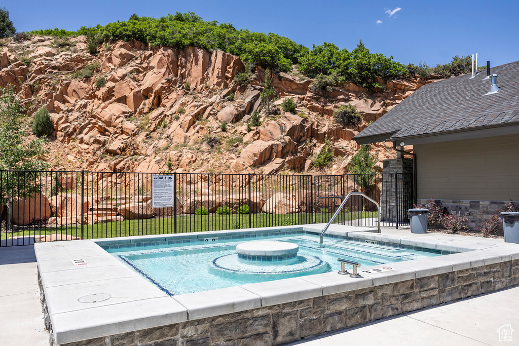 View of swimming pool with a hot tub