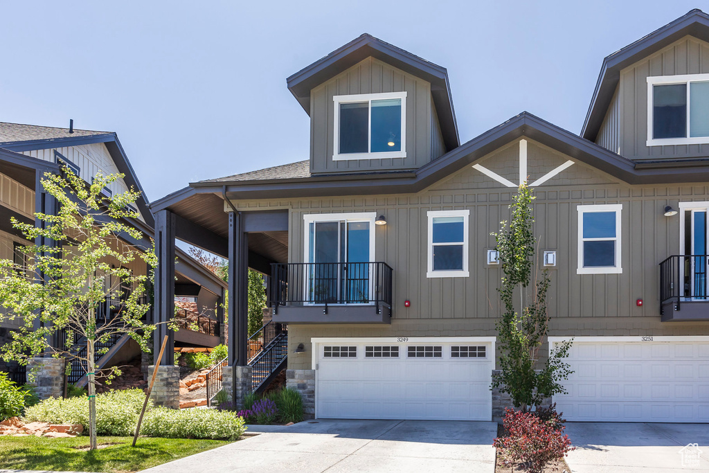 View of front of house with stairway, a garage, concrete driveway, and board and batten siding