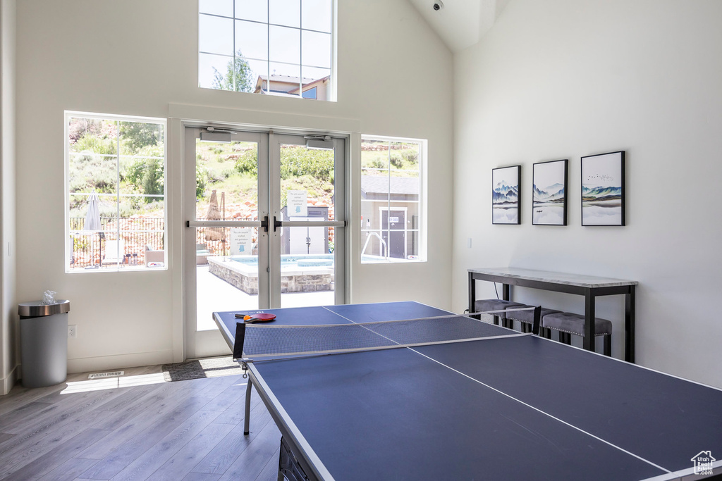 Game room with wood finished floors, high vaulted ceiling, and french doors