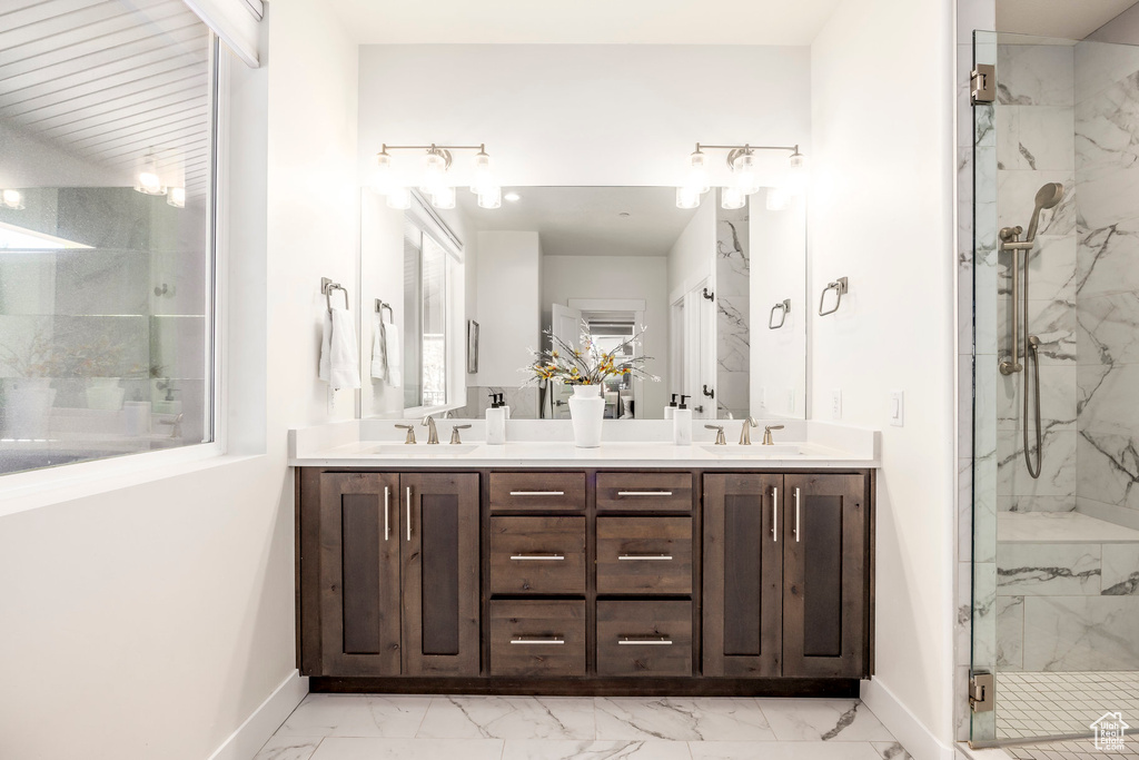 Full bathroom with marble finish flooring, a marble finish shower, and double vanity