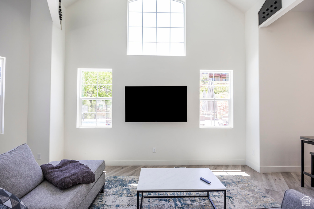 Living area featuring high vaulted ceiling and wood finished floors