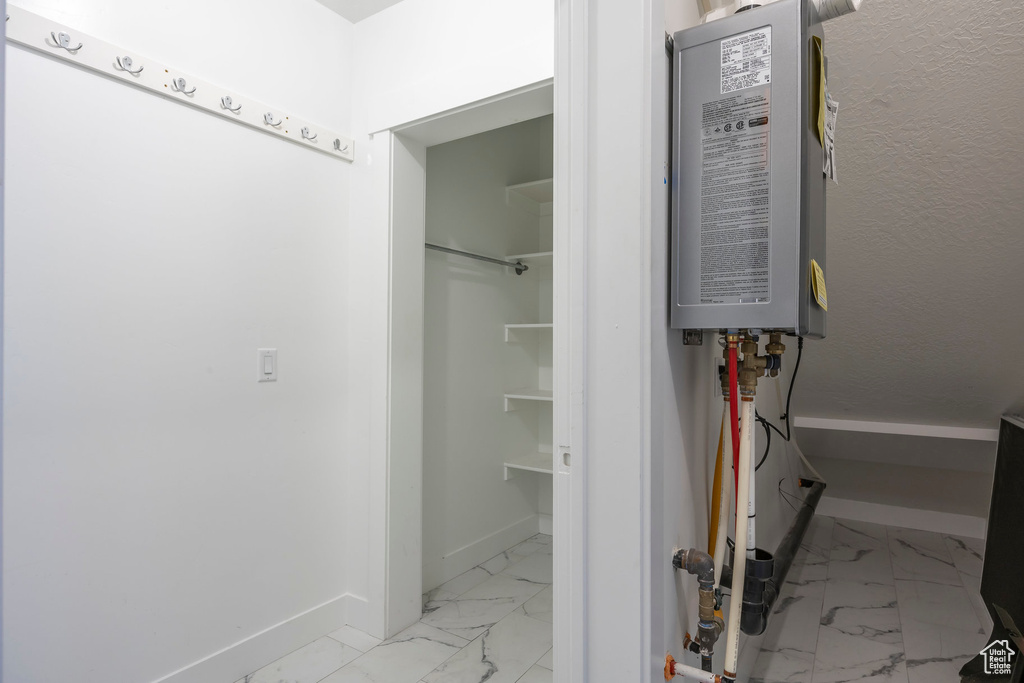 Bathroom featuring marble look tile flooring and baseboards