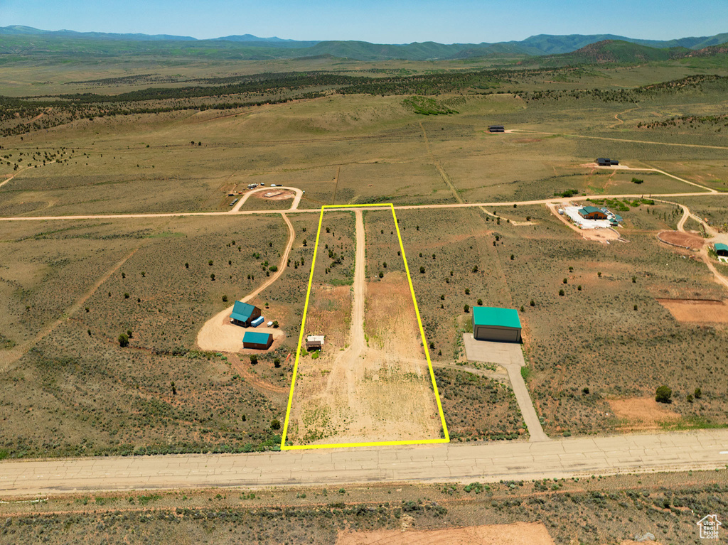 Aerial view of sparsely populated area with a mountain backdrop and property parcel outlined
