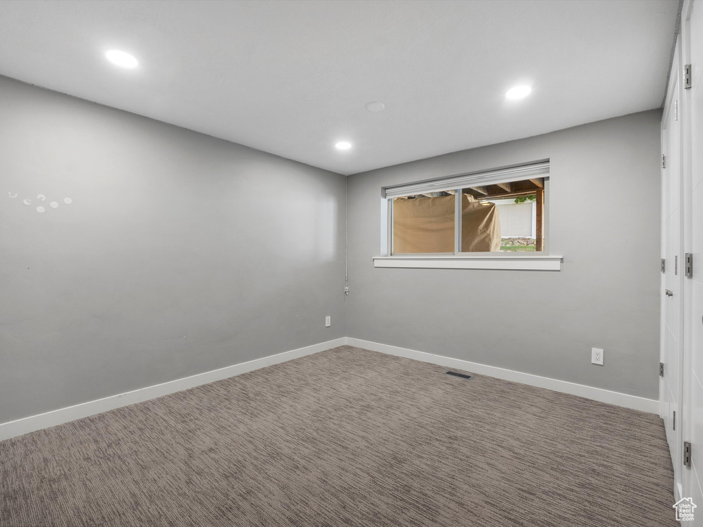 Carpeted empty room featuring recessed lighting
