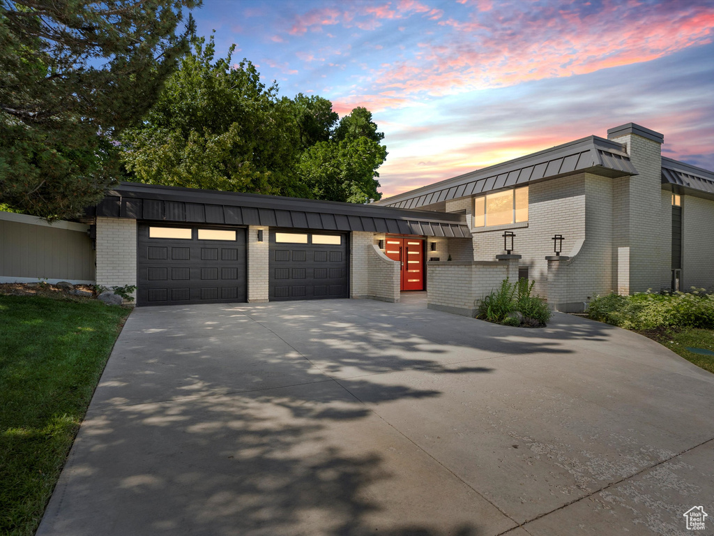 View of front of house featuring a garage, brick siding, and driveway