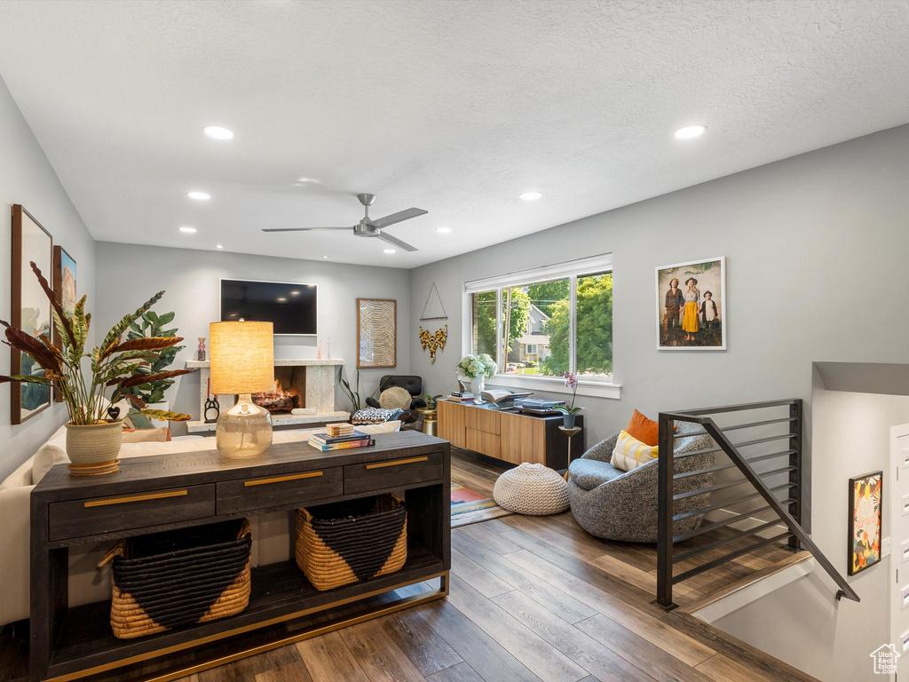 Office area featuring wood-type flooring, a ceiling fan, recessed lighting, and a warm lit fireplace
