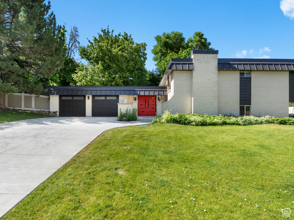 View of front of house featuring brick siding, driveway, and an attached garage