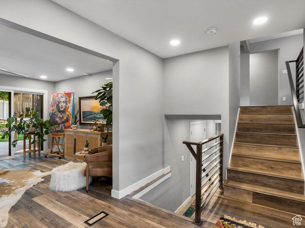 Stairway with hardwood / wood-style floors and recessed lighting