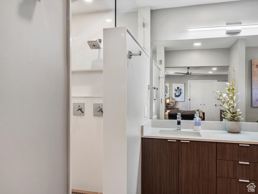 Bathroom featuring ensuite bath, vanity, and ceiling fan