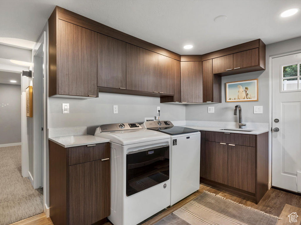 Kitchen with washing machine and clothes dryer, light countertops, light wood-style floors, and recessed lighting
