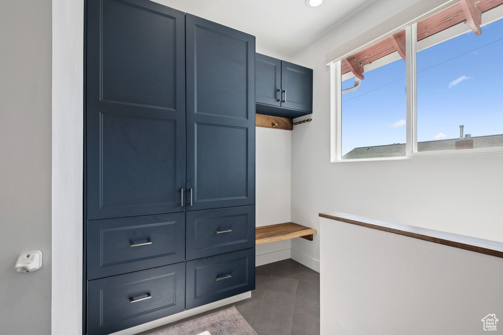 Mudroom featuring baseboards and dark tile patterned flooring