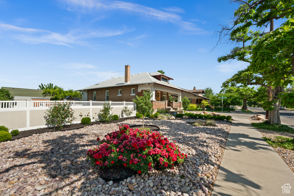 View of front of property featuring a chimney and brick siding