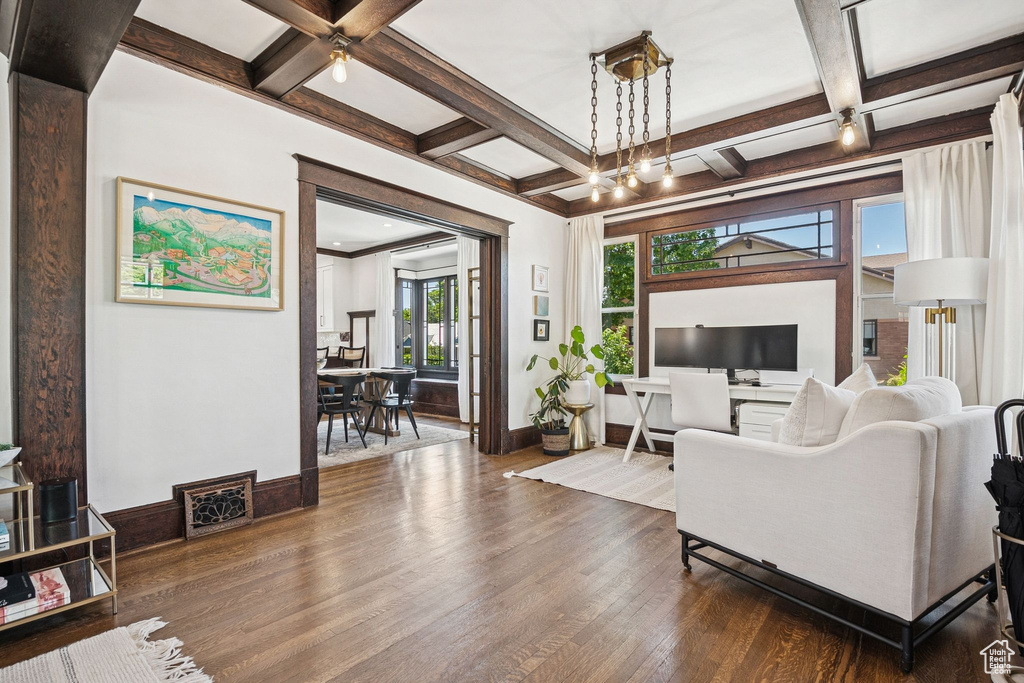 Living area with coffered ceiling, dark wood-type flooring, beamed ceiling, and ceiling fan