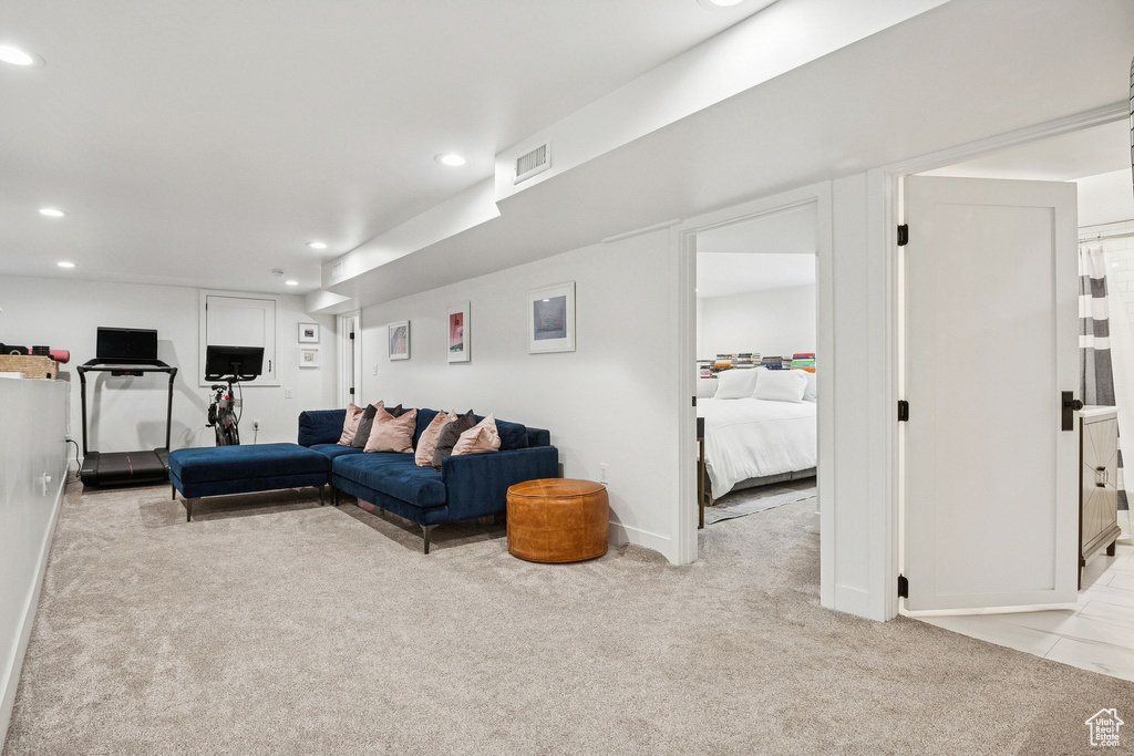 Living area with light carpet and recessed lighting