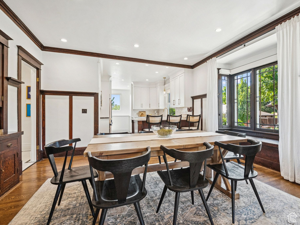 Dining space featuring ornamental molding, dark wood-style flooring, and recessed lighting