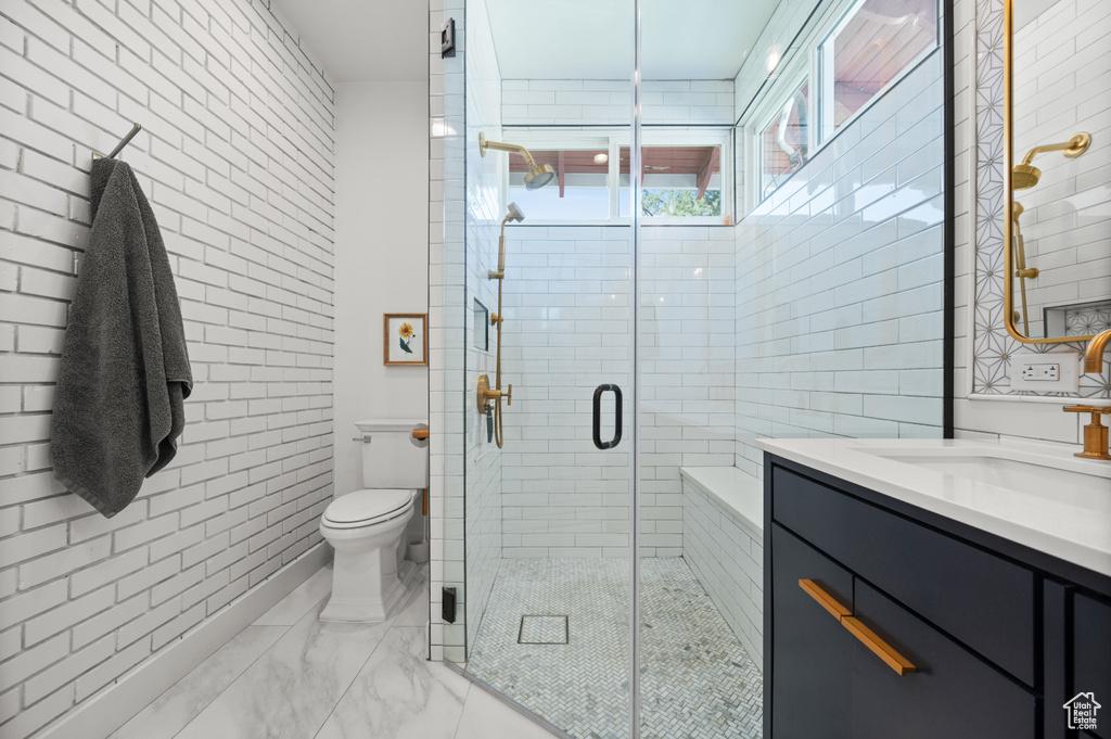 Bathroom with vanity, marble finish flooring, and a stall shower