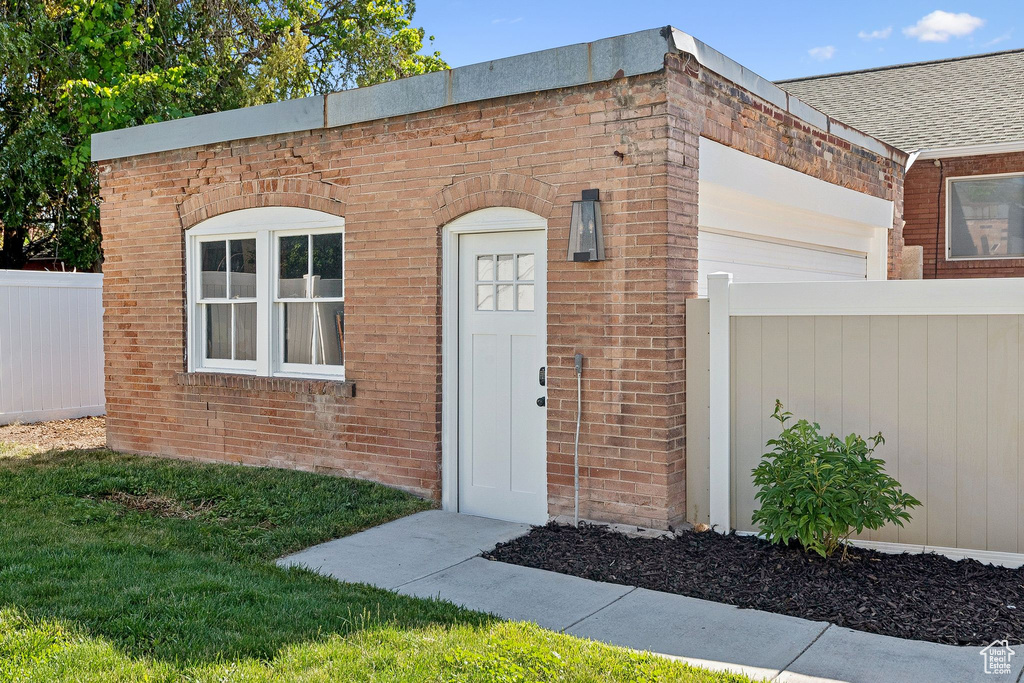Property entrance with brick siding and an attached garage