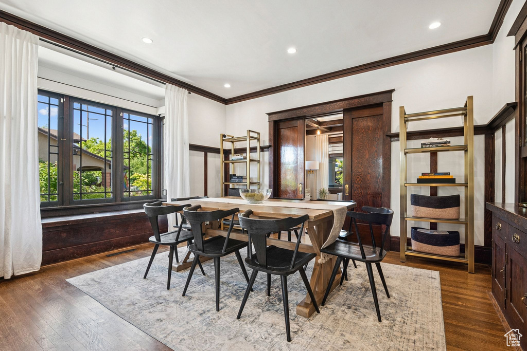 Dining room featuring crown molding, plenty of natural light, dark wood finished floors, and recessed lighting