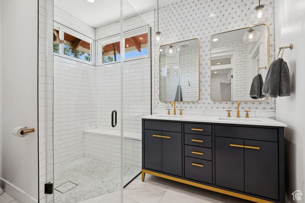 Full bathroom featuring double vanity and a shower stall