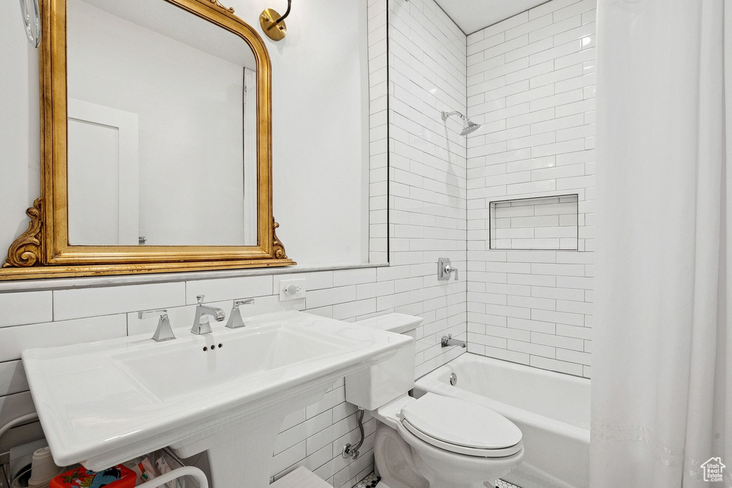 Full bathroom featuring tile walls and shower / bath combination with curtain