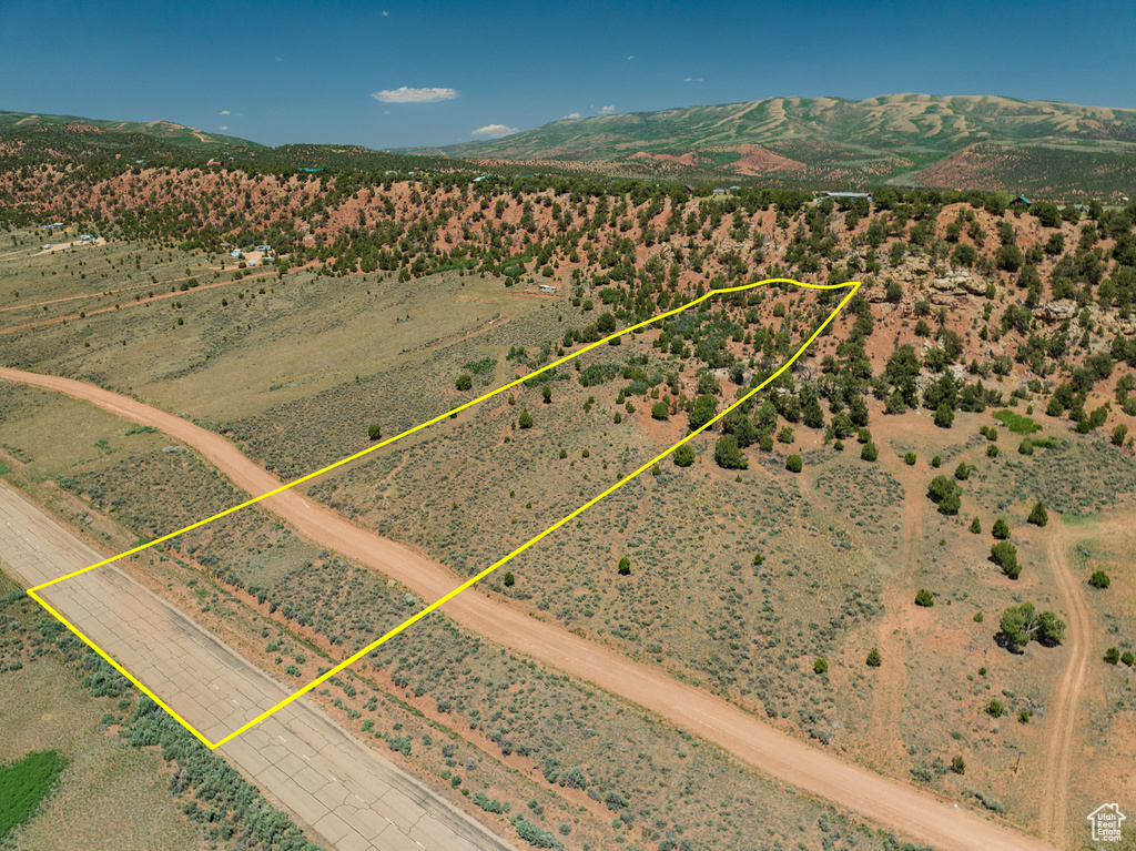 Aerial view of sparsely populated area with property boundaries highlighted and a mountainous background