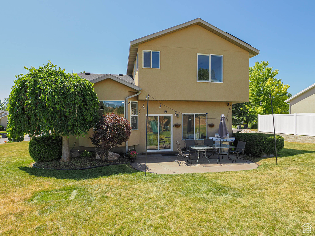 Rear view of property featuring stucco siding and a patio area
