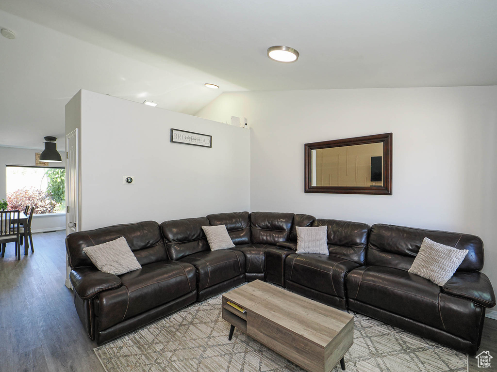 Living room with wood finished floors and vaulted ceiling