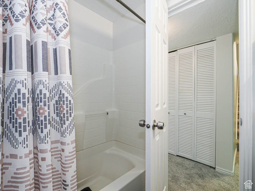 Bathroom featuring shower / bath combo with shower curtain and a closet