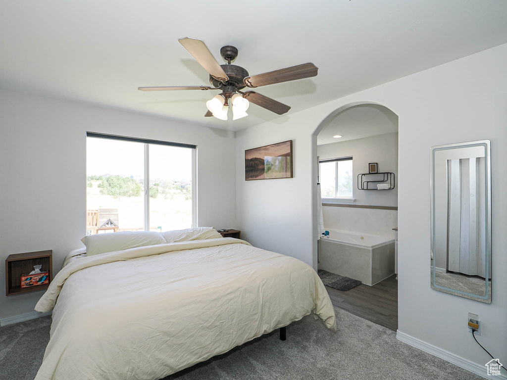 Bedroom featuring carpet floors, arched walkways, and a ceiling fan