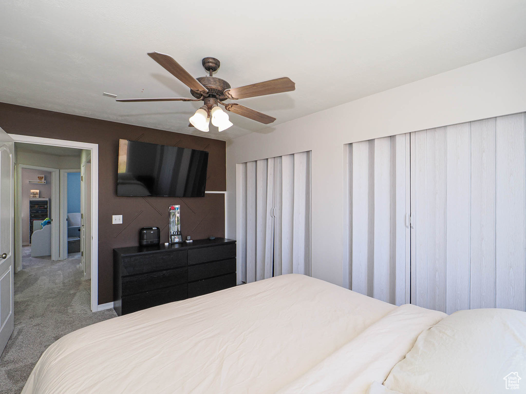 Carpeted bedroom featuring a ceiling fan