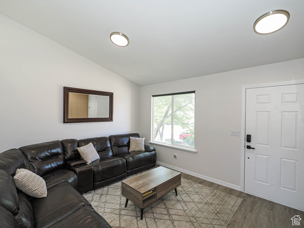 Living area with vaulted ceiling and wood finished floors