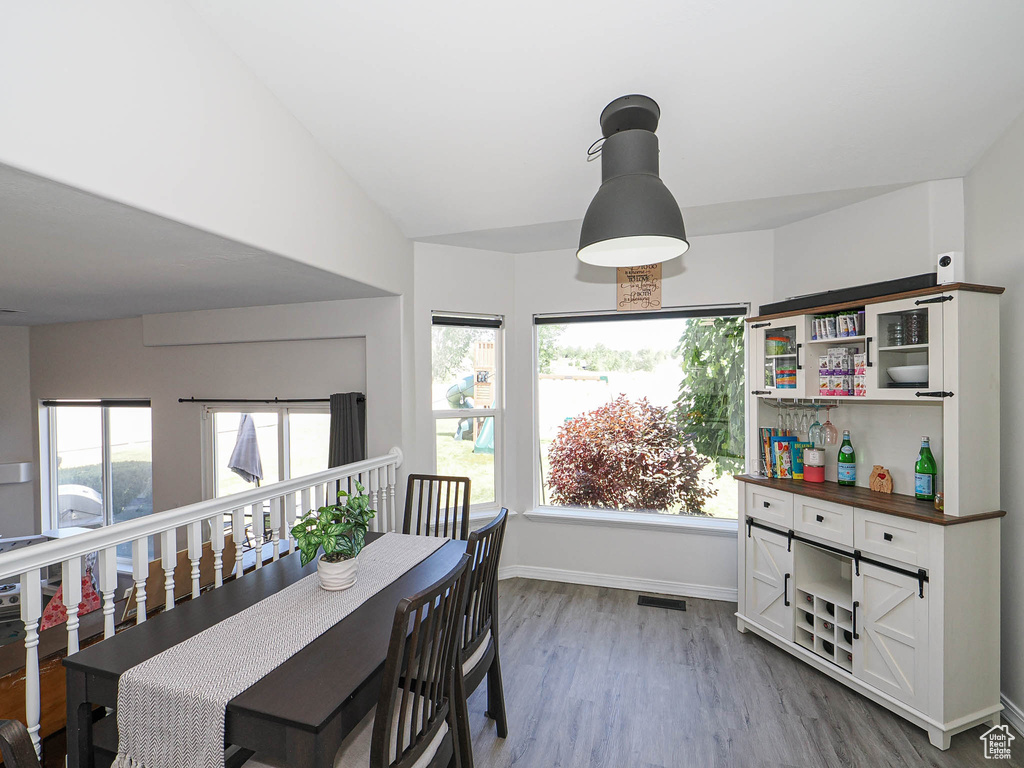 Dining area with dark wood-type flooring and vaulted ceiling