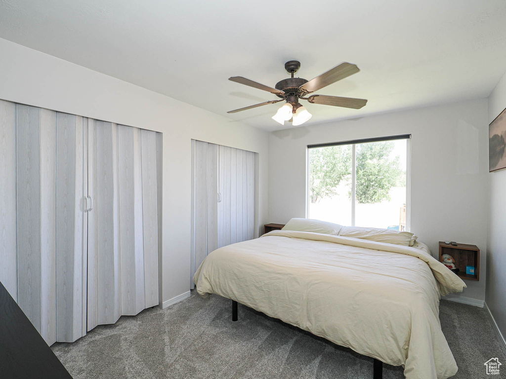 Bedroom featuring carpet floors, ceiling fan, and multiple closets