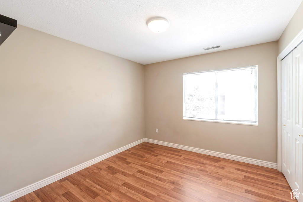 Unfurnished bedroom featuring light wood-type flooring and a closet