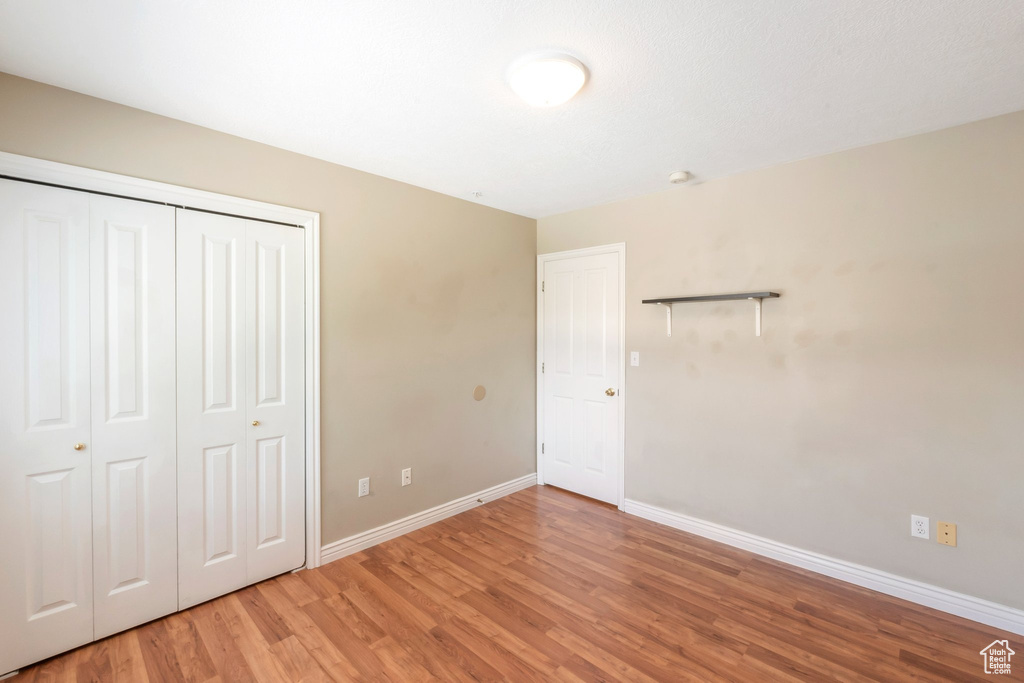 Unfurnished bedroom featuring light wood-type flooring and a closet