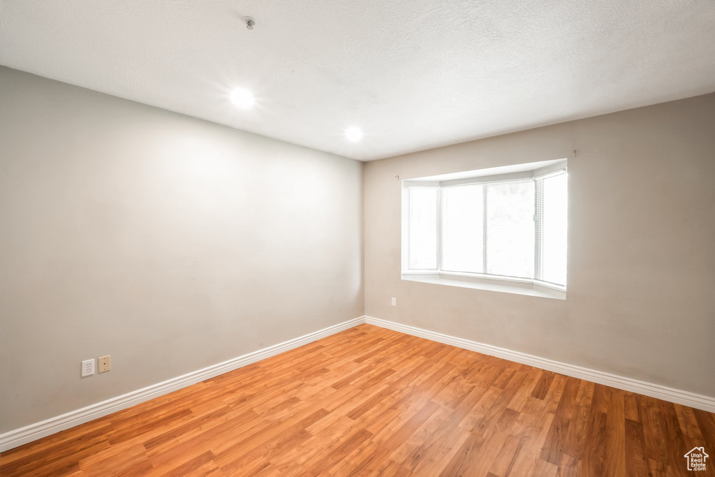 Empty room with light wood-type flooring and recessed lighting