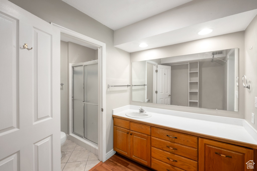 Full bath featuring a stall shower, vanity, a spacious closet, and recessed lighting