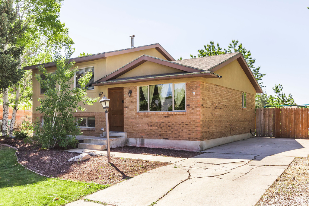 View of front of property featuring brick siding and concrete driveway