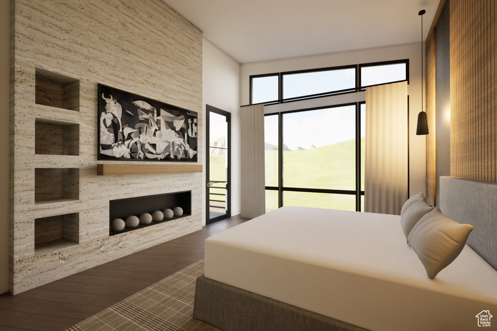 Bedroom featuring wood finished floors, access to exterior, and a large fireplace
