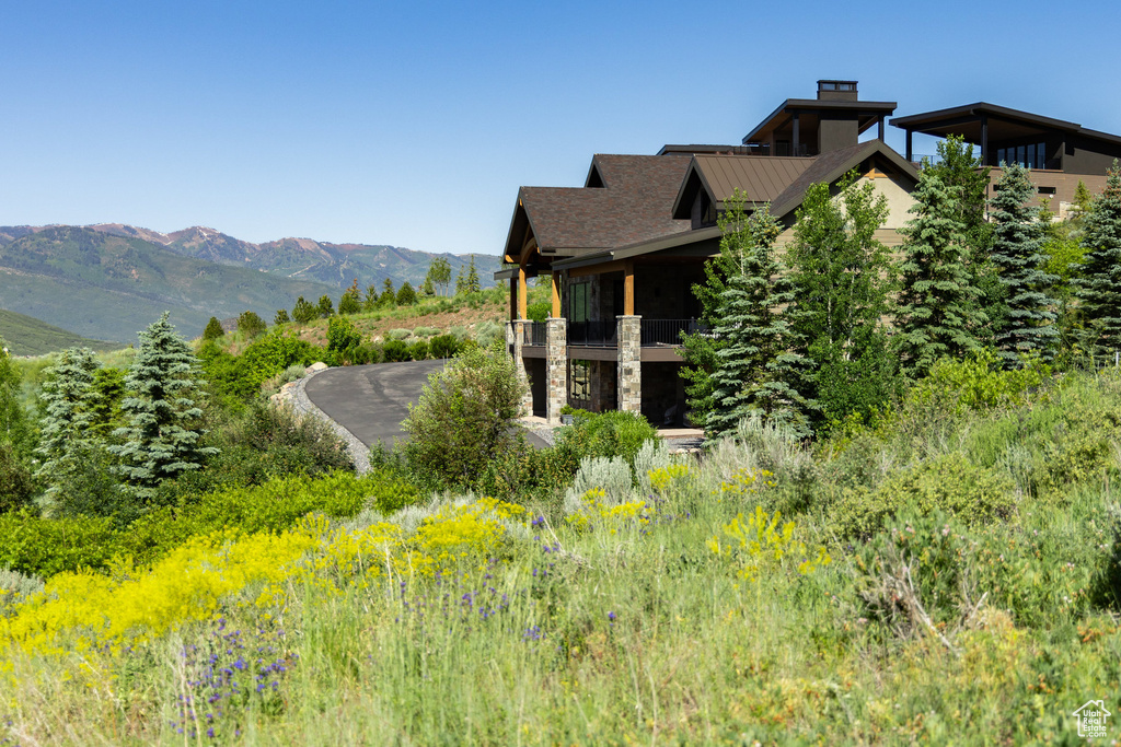 View of property exterior featuring a balcony, stone siding, and a mountain view