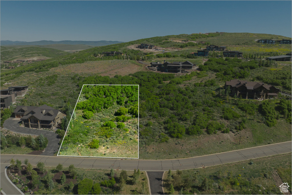 Aerial overview of property\'s location featuring property parcel outlined and a mountain backdrop