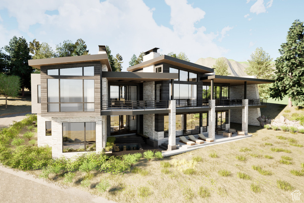Back of property featuring a balcony, stone siding, a patio area, and a chimney