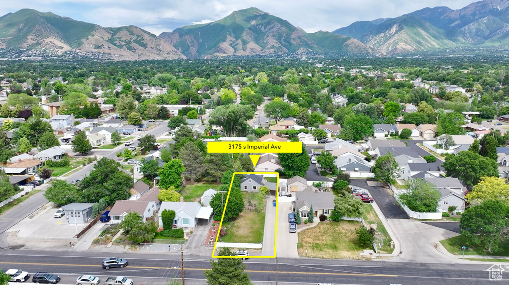 Aerial view of residential area with mountains and property boundaries highlighted