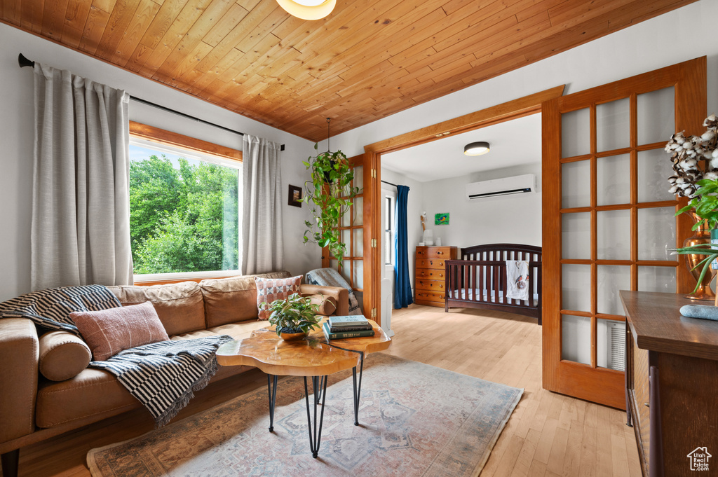 Living room with a wall mounted air conditioner, light wood-style floors, and wood ceiling