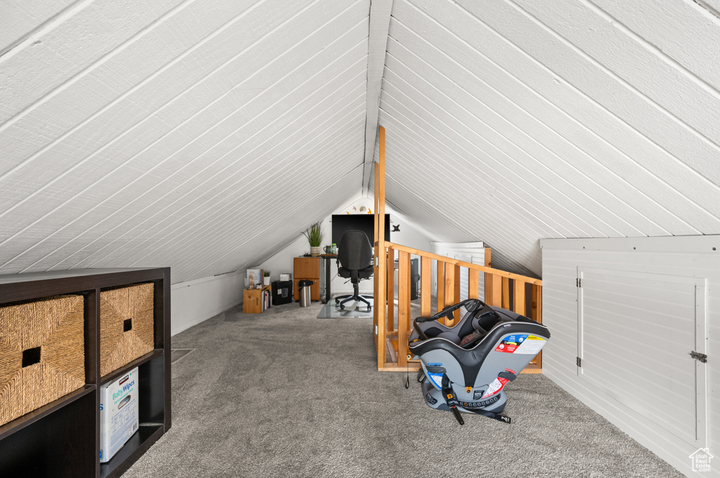 Additional living space with carpet flooring and vaulted ceiling