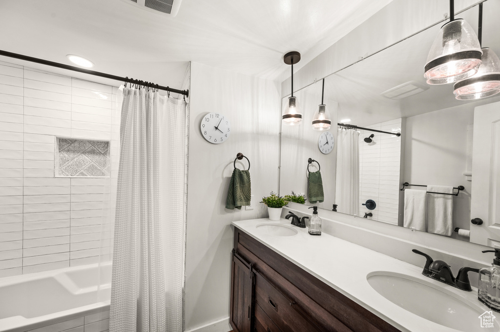 Bathroom featuring shower / bath combo with shower curtain and double vanity